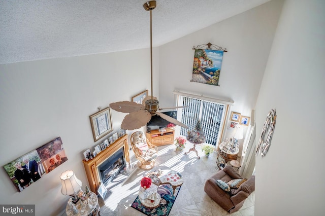 living room with ceiling fan and a textured ceiling