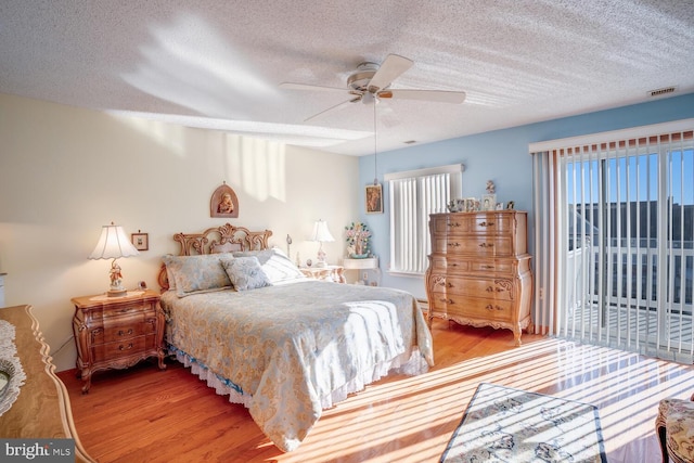 bedroom featuring wood-type flooring, multiple windows, and ceiling fan