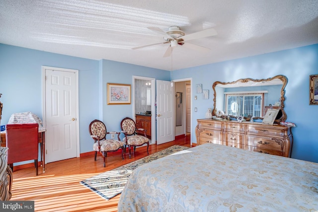 bedroom featuring wood-type flooring, a textured ceiling, and ceiling fan