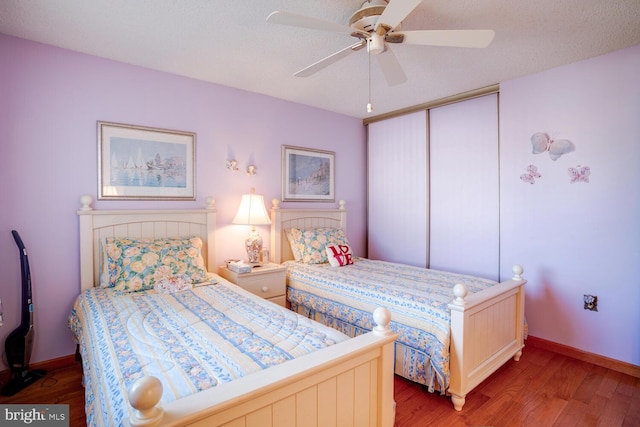 bedroom with hardwood / wood-style flooring, ceiling fan, a textured ceiling, and a closet