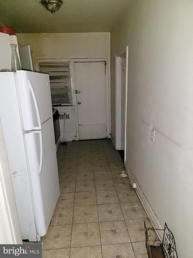 kitchen with white refrigerator and white cabinetry