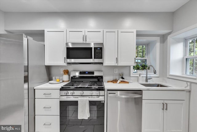 kitchen with white cabinets, stainless steel appliances, and sink