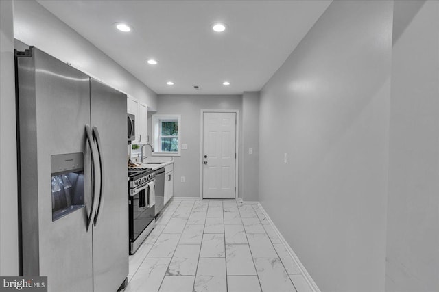 kitchen featuring stainless steel appliances, white cabinetry, and sink