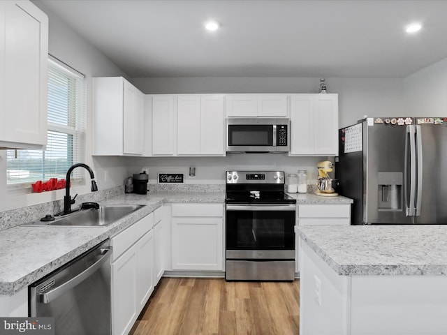 kitchen with white cabinets, light wood-type flooring, sink, and appliances with stainless steel finishes