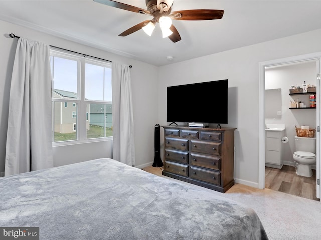 bedroom featuring light hardwood / wood-style floors, ensuite bath, and ceiling fan