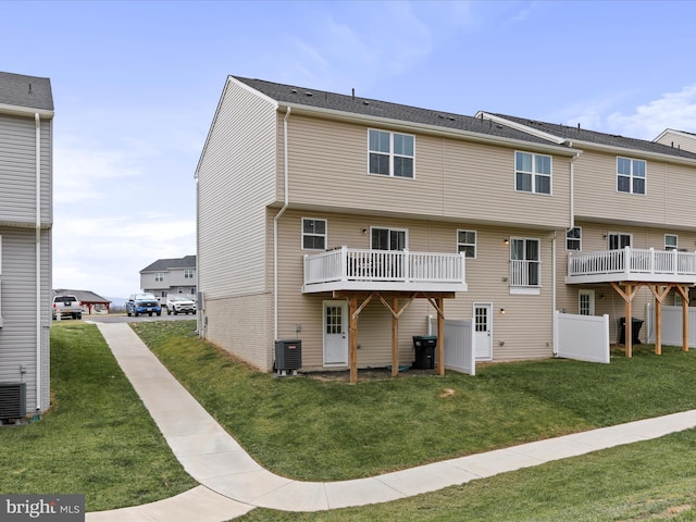 rear view of house with central air condition unit, a yard, and a wooden deck