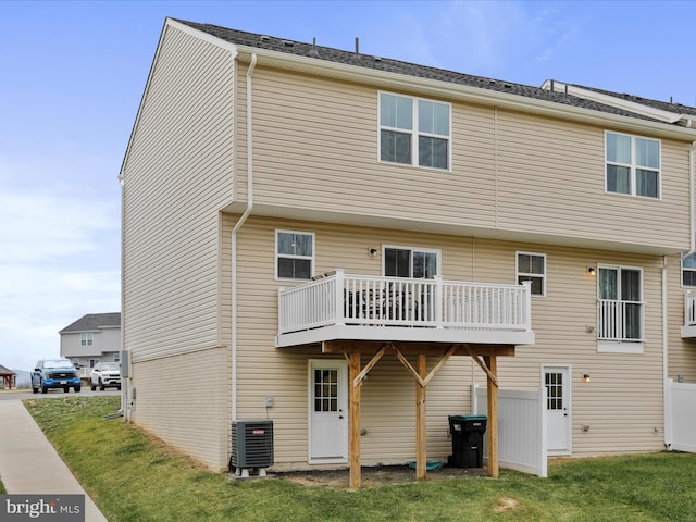 back of house featuring central AC unit, a lawn, and a wooden deck