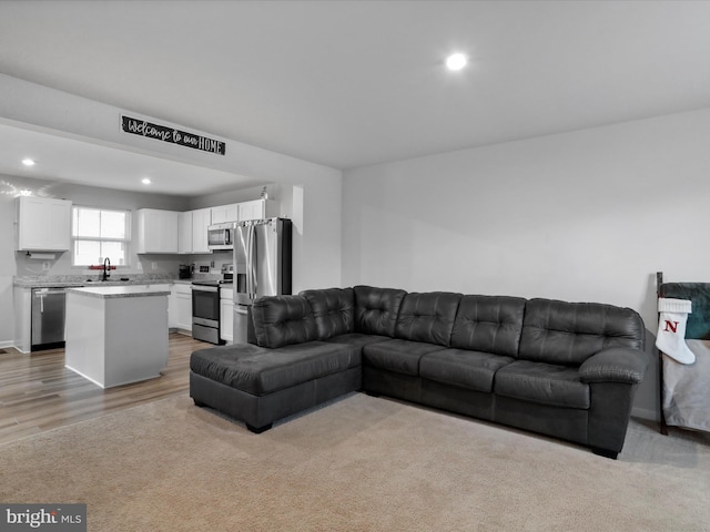 living room with sink and light hardwood / wood-style flooring