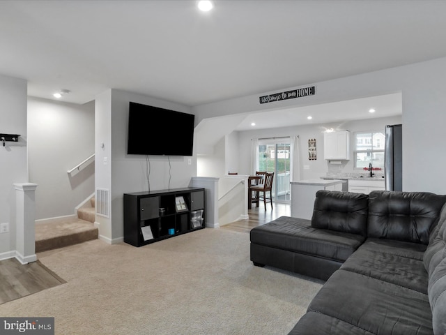 carpeted living room featuring sink