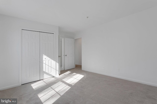 unfurnished bedroom with a closet and light carpet