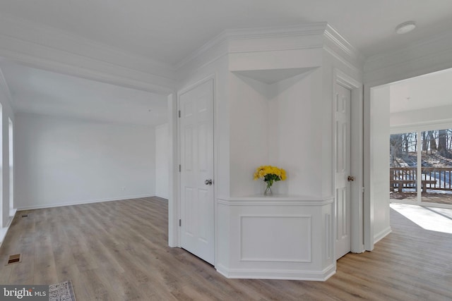 corridor with crown molding and light hardwood / wood-style floors