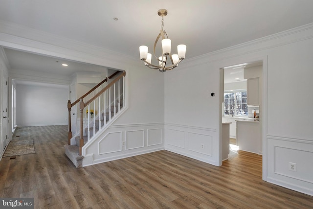 unfurnished dining area with ornamental molding, a notable chandelier, and dark hardwood / wood-style flooring