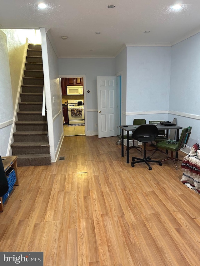 interior space with ornamental molding and light hardwood / wood-style flooring