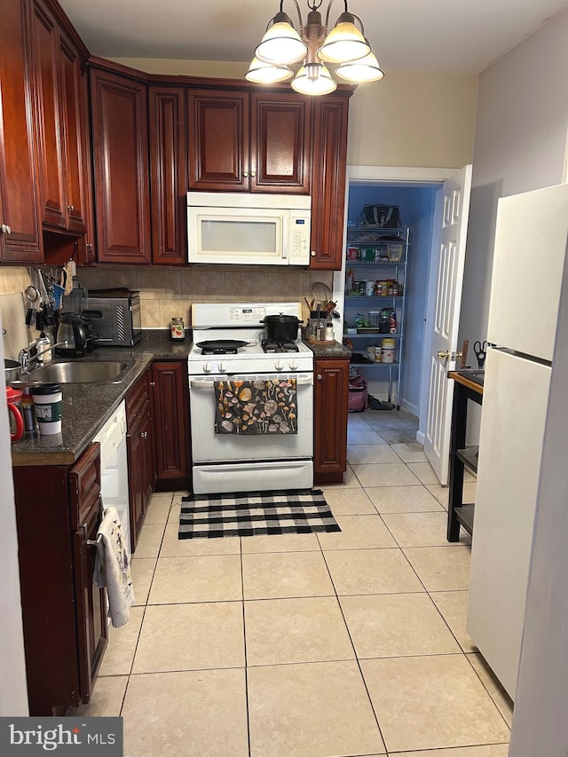 kitchen with backsplash, light tile patterned floors, hanging light fixtures, and white appliances