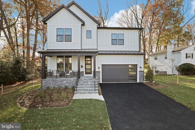 modern farmhouse featuring a front yard, a porch, and a garage