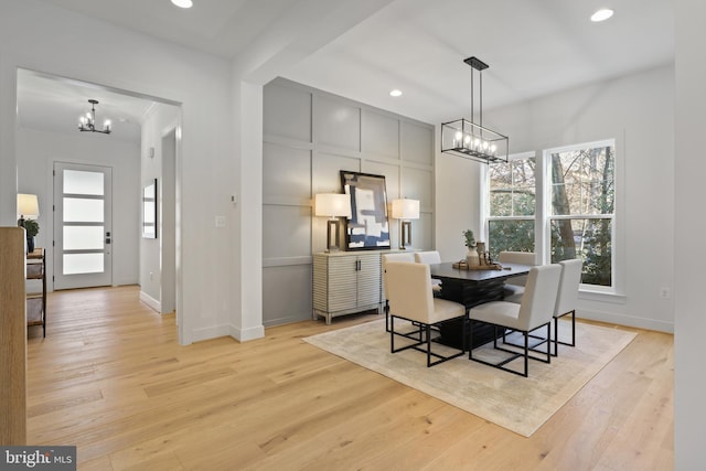 dining area featuring light hardwood / wood-style flooring and an inviting chandelier