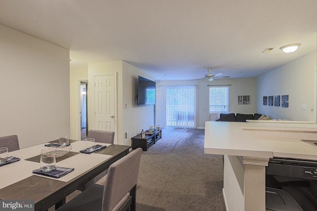 carpeted dining room with ceiling fan