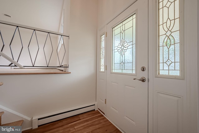 foyer with plenty of natural light, a baseboard radiator, and wood-type flooring