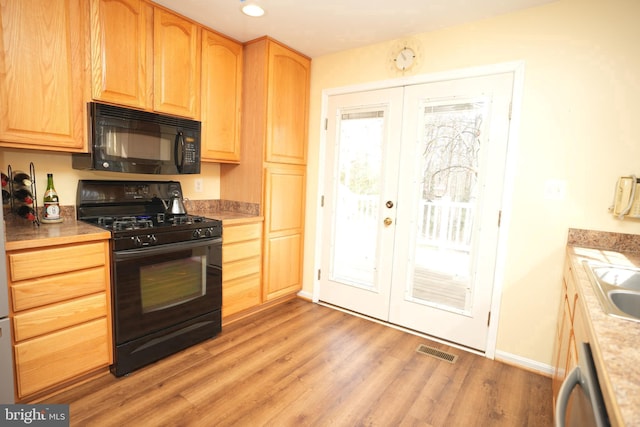 37978 George F Dr, Mechanicsville, MD 20659 - kitchen with light wood finished floors, visible vents, light brown cabinets, french doors, and black appliances