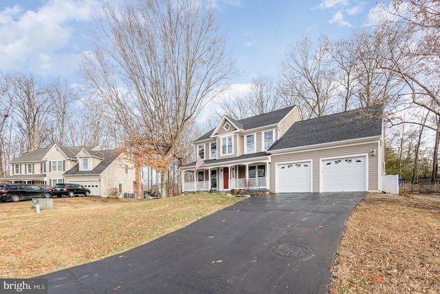 view of property featuring a porch, a garage, and a front yard