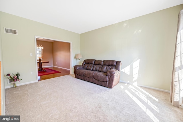 living room featuring light carpet, an inviting chandelier, and plenty of natural light