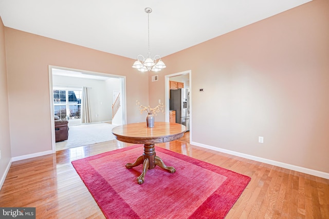 dining area featuring a notable chandelier and light wood-type flooring