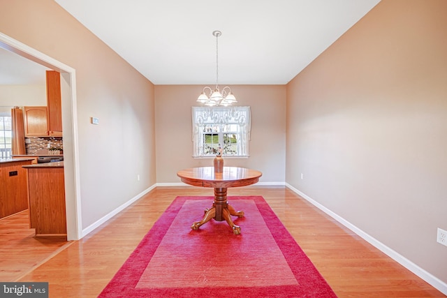 dining space featuring a chandelier and light wood-type flooring