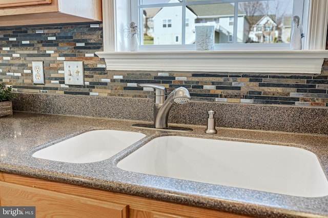 details featuring tasteful backsplash and sink