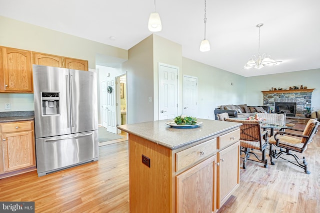 kitchen with a notable chandelier, light wood-type flooring, stainless steel fridge with ice dispenser, and hanging light fixtures