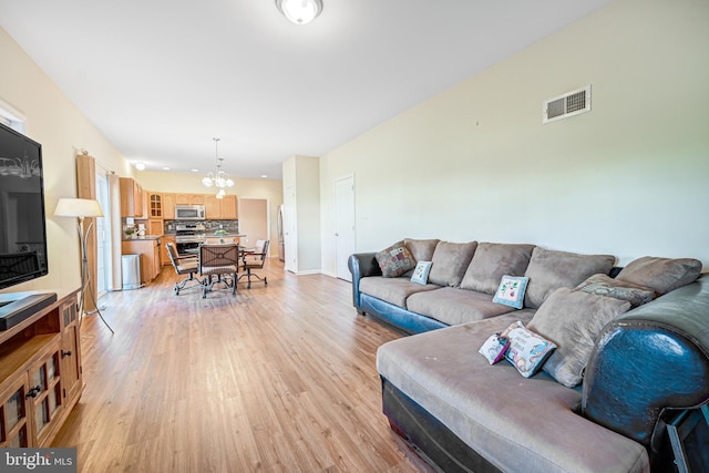 living room with a chandelier and light wood-type flooring