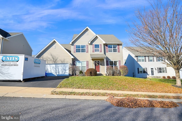 view of front of home with a front yard and a garage