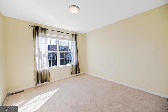 spare room featuring light colored carpet