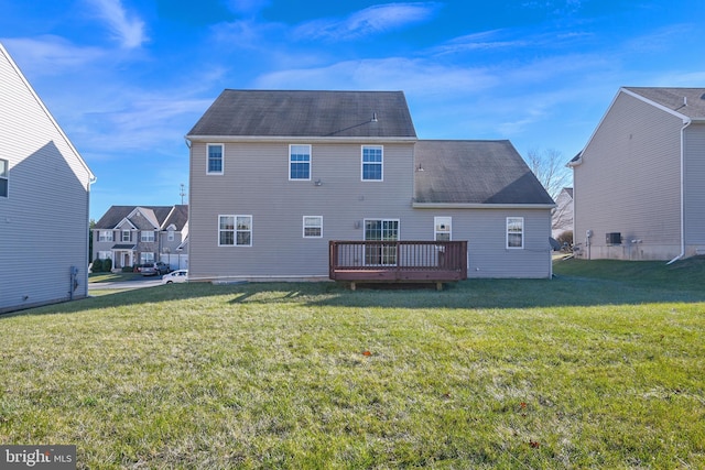 rear view of property featuring a lawn and a wooden deck