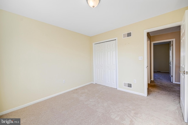 unfurnished bedroom with light carpet and a closet