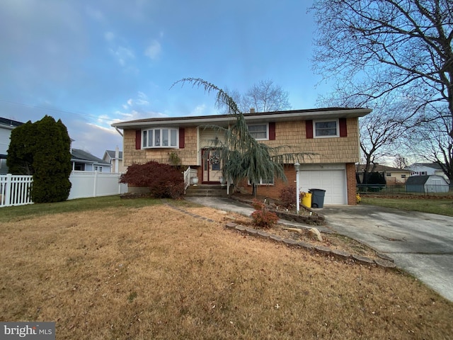 bi-level home featuring a garage and a front lawn