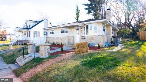 view of front facade with a front yard and central AC unit