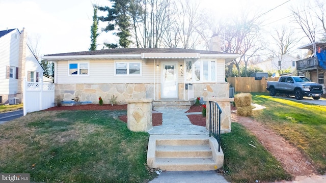 view of front of home featuring central air condition unit and a front yard