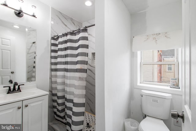 bathroom featuring curtained shower, vanity, and toilet