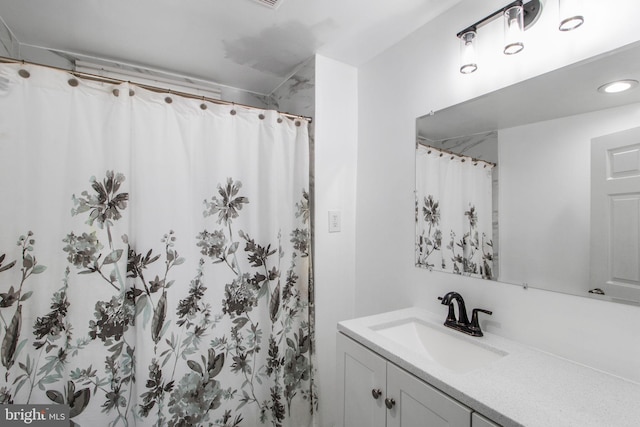 bathroom with curtained shower and vanity