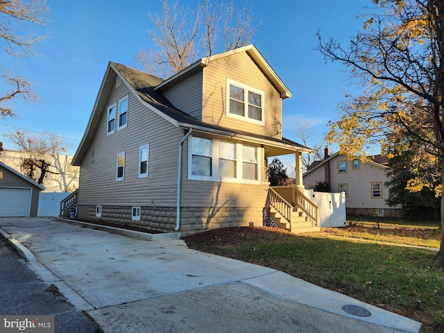 view of front of home with a front lawn, an outdoor structure, and a garage