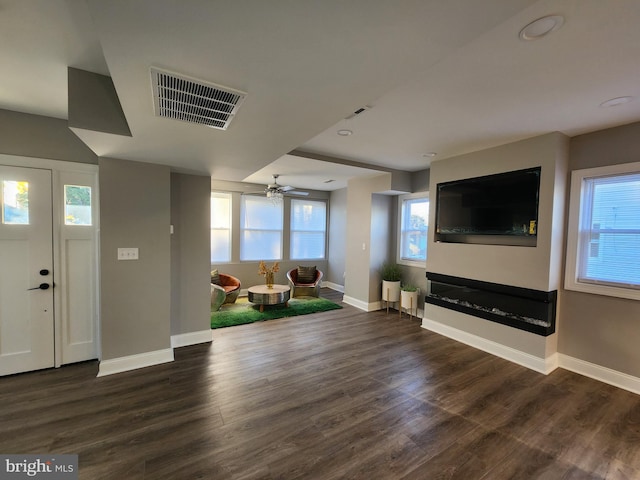 unfurnished living room with ceiling fan and dark hardwood / wood-style flooring