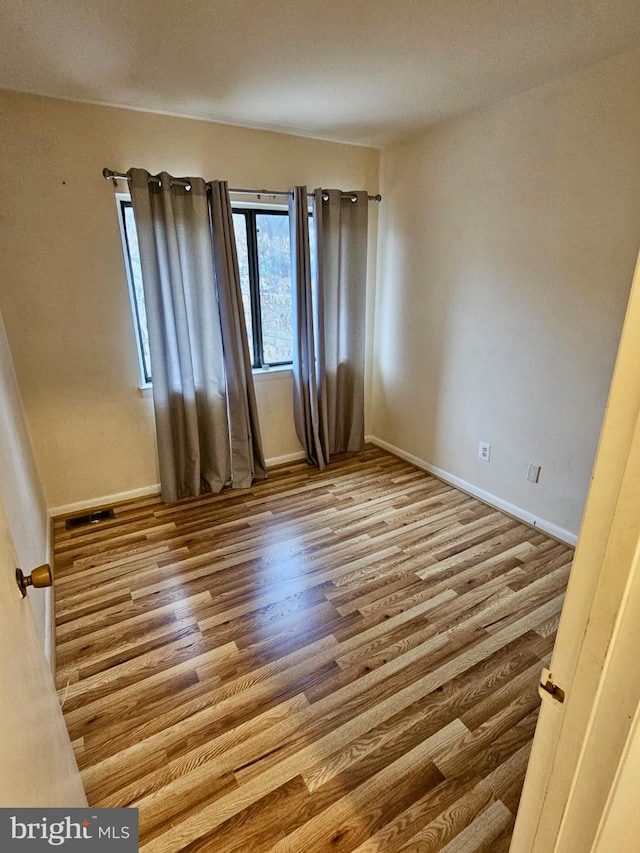 empty room with light hardwood / wood-style flooring