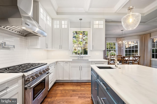 kitchen with white cabinets, high end stainless steel range oven, wall chimney exhaust hood, decorative light fixtures, and dark hardwood / wood-style flooring