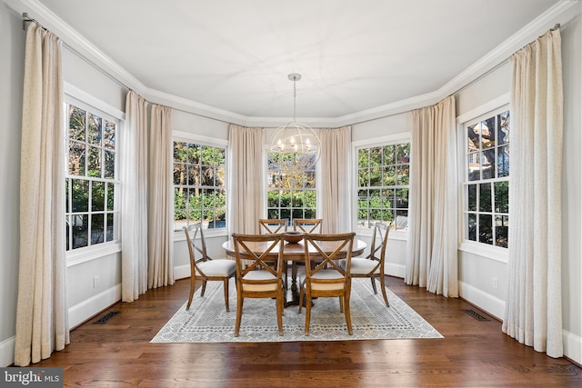 dining area featuring crown molding, plenty of natural light, a chandelier, and dark hardwood / wood-style floors