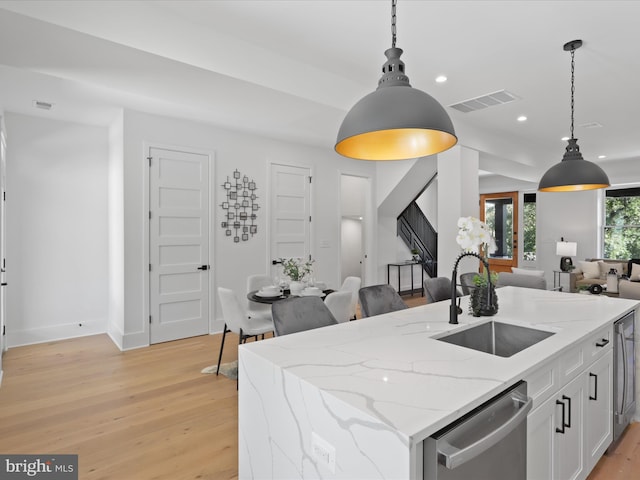 kitchen featuring dishwasher, decorative light fixtures, white cabinetry, and sink