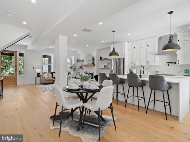 dining space featuring sink and light hardwood / wood-style flooring