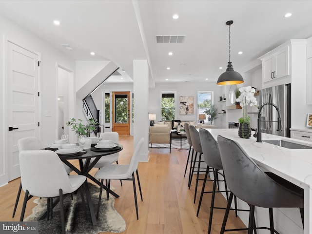 dining area with light hardwood / wood-style flooring and sink