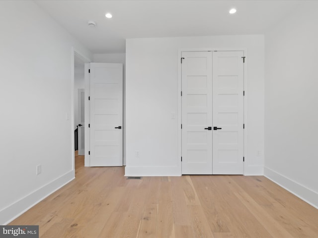 unfurnished bedroom featuring a closet and light wood-type flooring