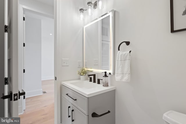 bathroom featuring vanity, hardwood / wood-style flooring, and toilet