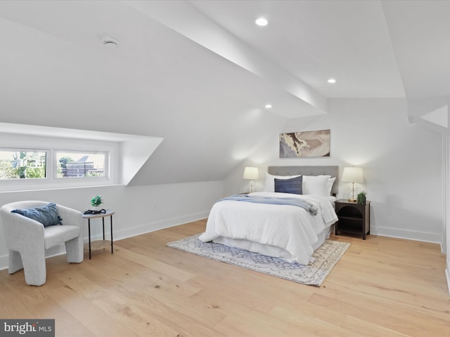 bedroom with light wood-type flooring and lofted ceiling